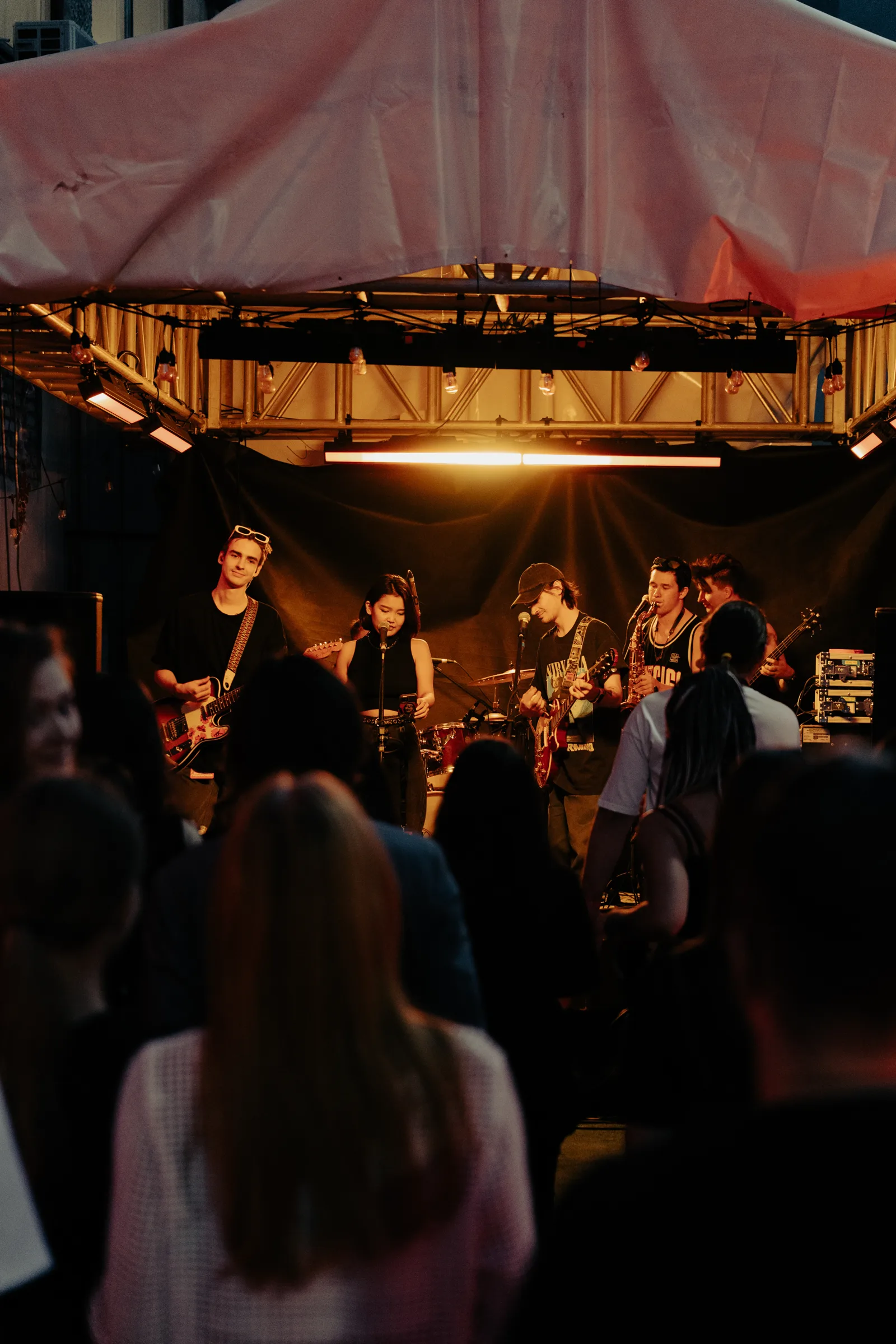 A band under the tent stage, the audience in front