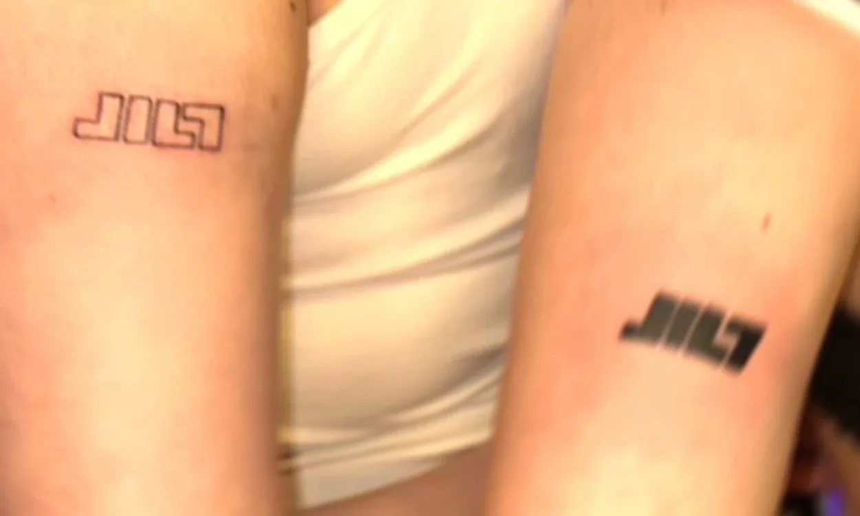 Two arms with fresh JILT tattoos